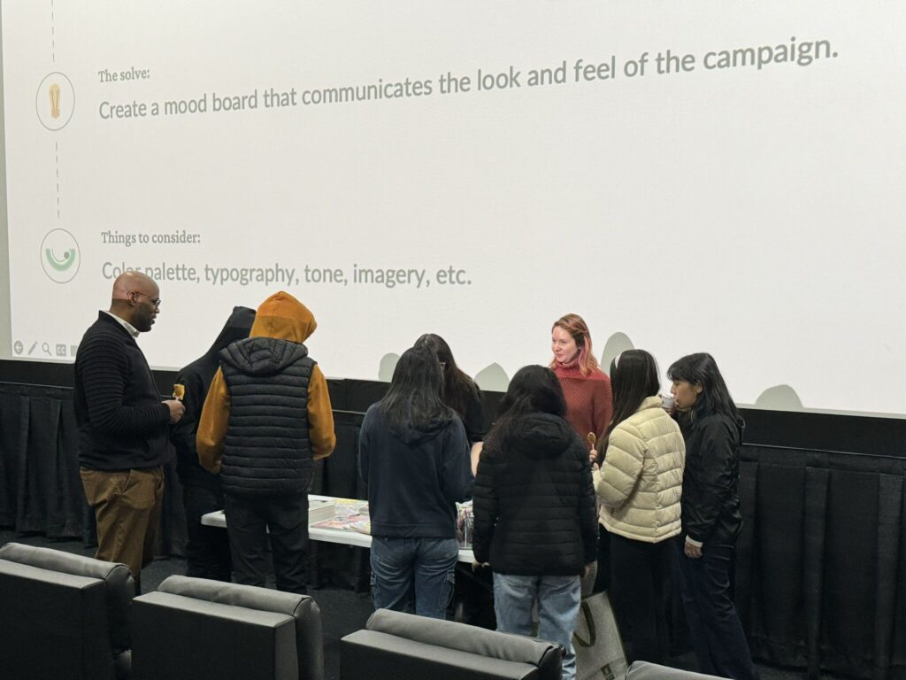 Group discussing in front of a presentation slide about creating a mood board.