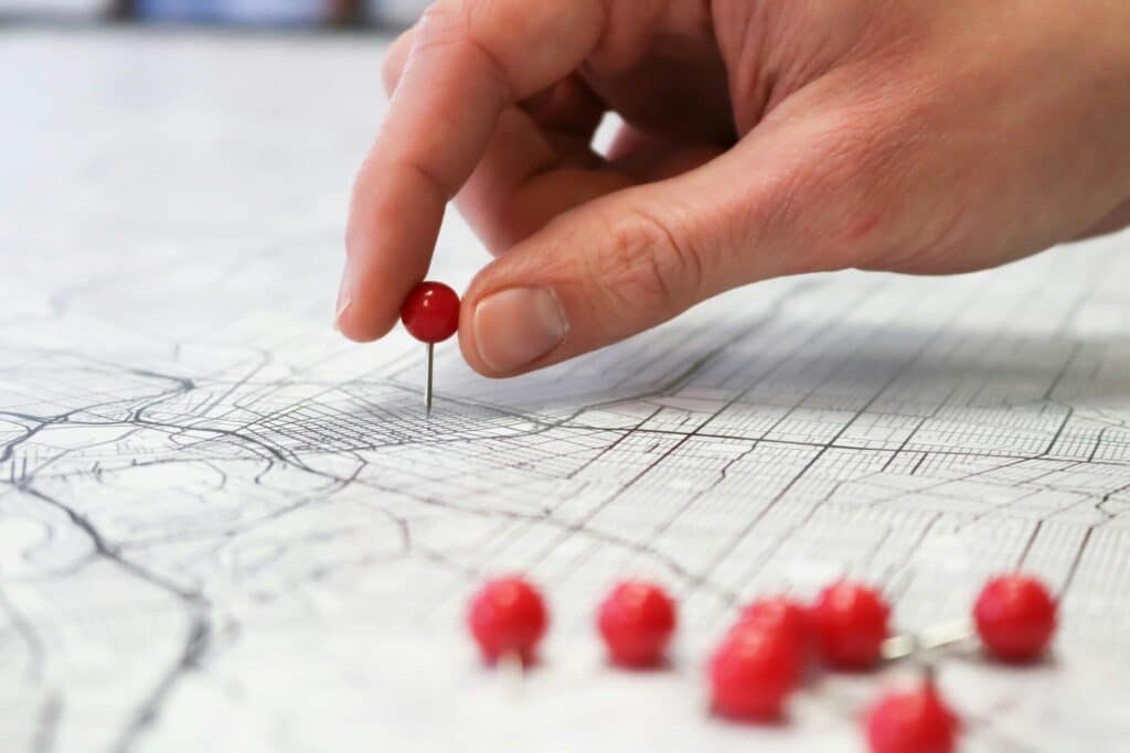 Local SEO services 4 Hand placing a red-topped pin into a map. Represents local SEO services.