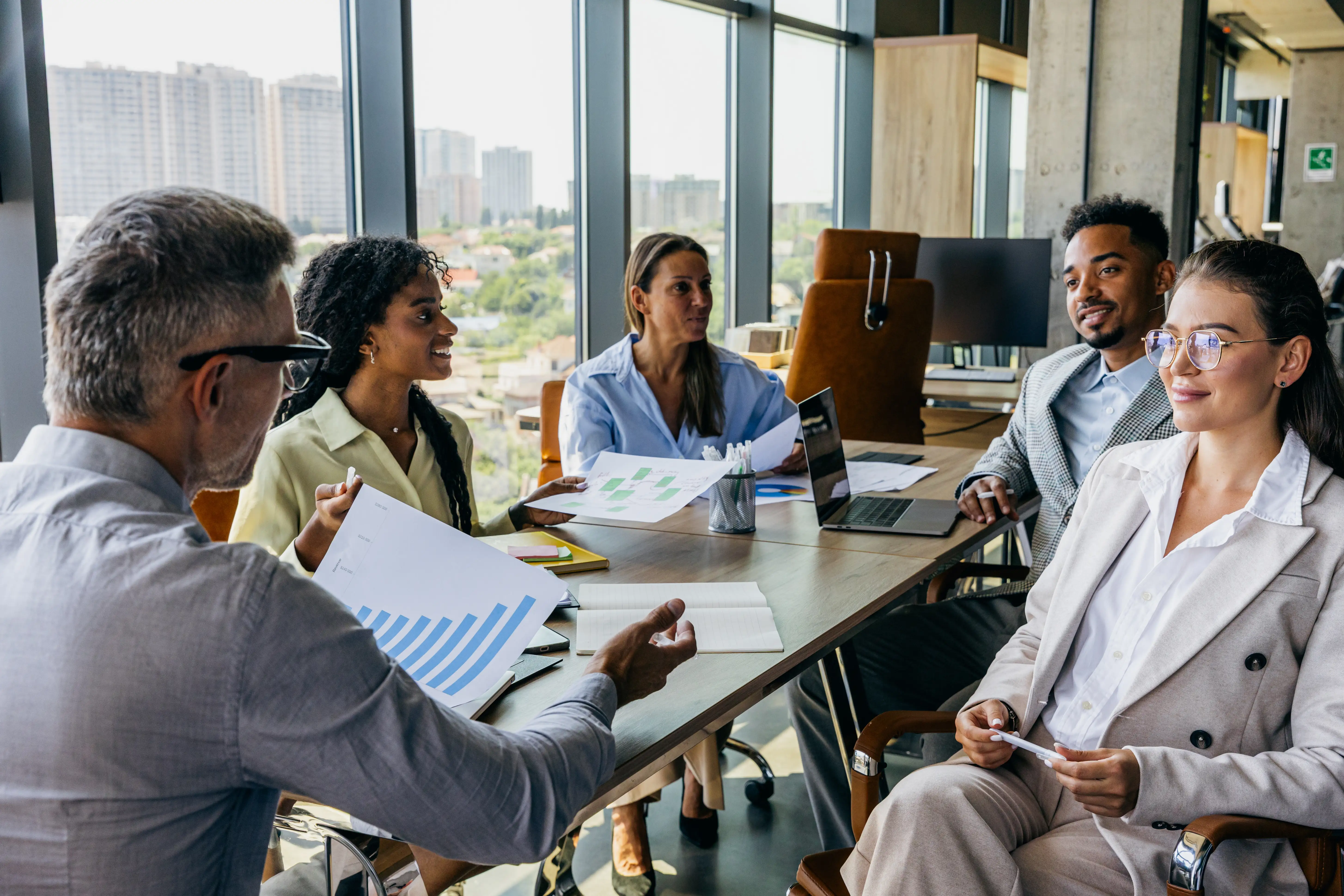 The Growth Engine Framework: Why Tactics Without Strategy Plateau 3 Diverse team collaborating around a conference table with charts and laptops in a modern office