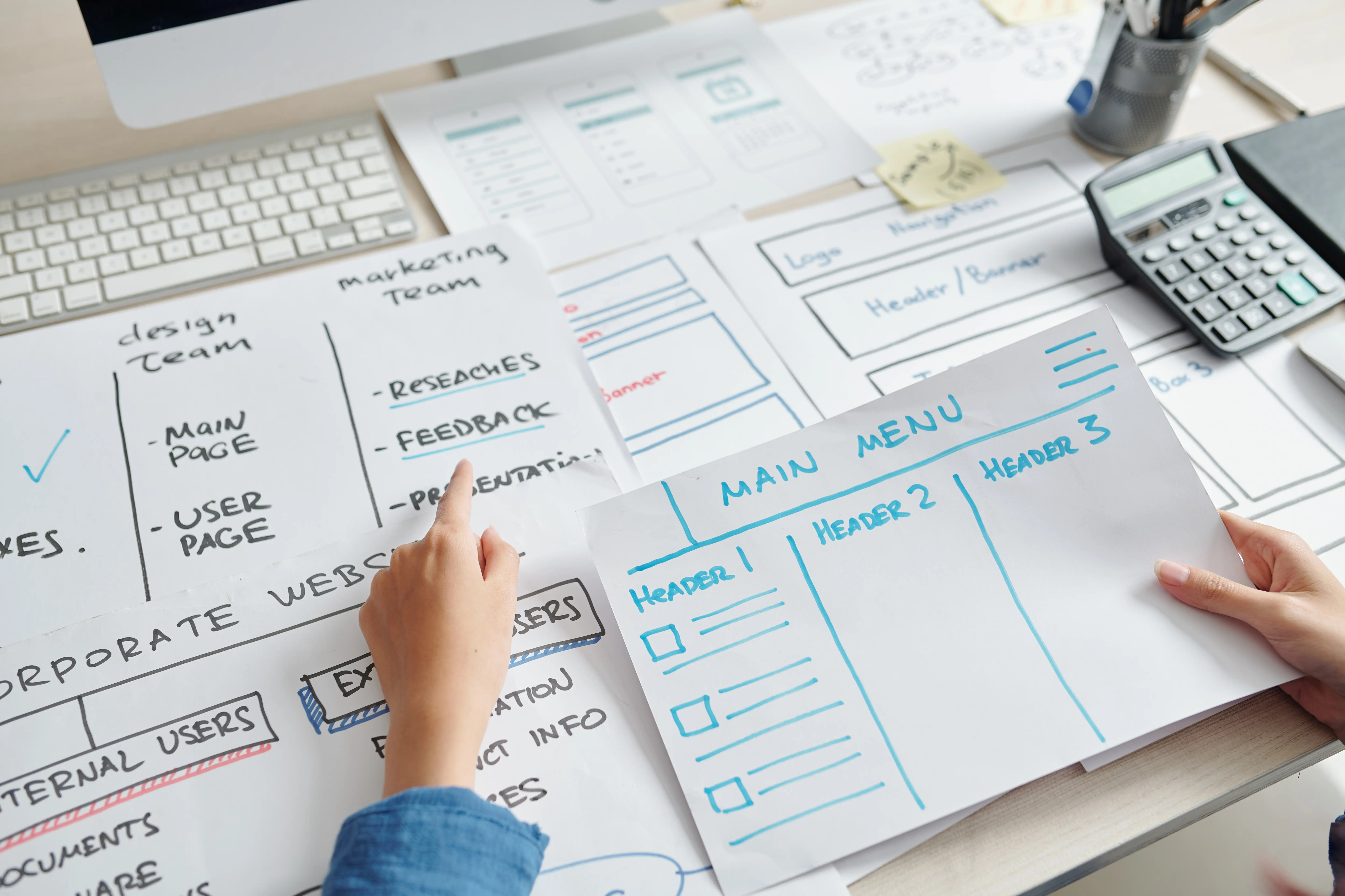 The Growth Engine Framework: Why Tactics Without Strategy Plateau 2 Designer reviewing hand-drawn website wireframes and layout sketches on a desk