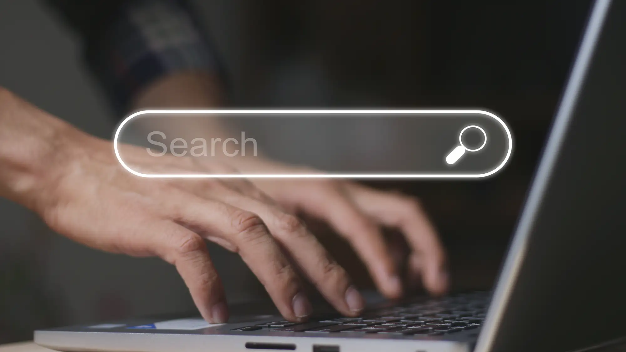 Getting a Clearer Audience Picture with Server-Side Tracking 3 Close-up of hands typing on a laptop with a search bar overlay, representing a user's online activity being tracked